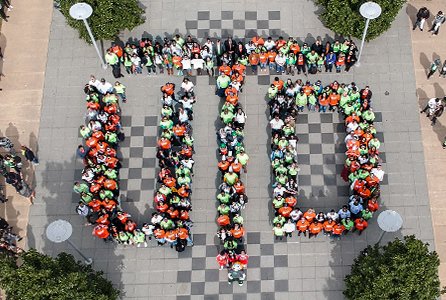 Many faculty and staff members forming the UT Dallas monogram on the chess plaza.
